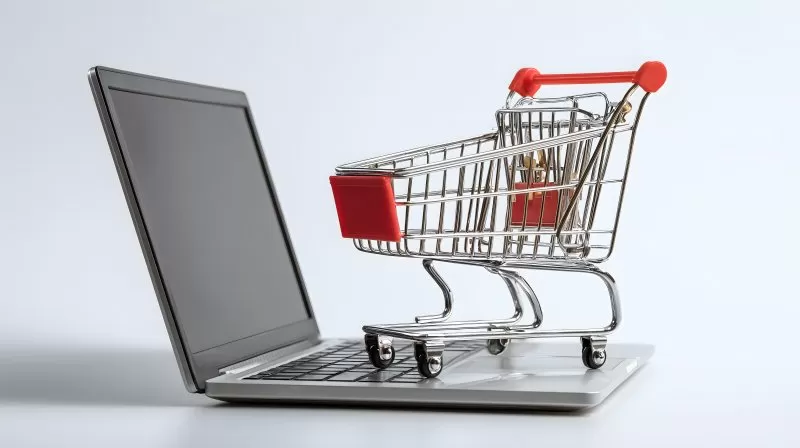 Laptop mit Miniatur Einkaufswagen Symbol für Online Shopping