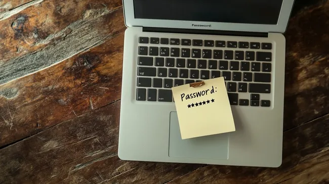 Laptop mit verdecktem Passwort auf Holztisch