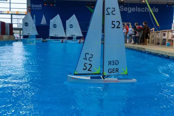 Large indoor pool with miniature sailboats promotes sailing school at exhibition boot Düsseldorf