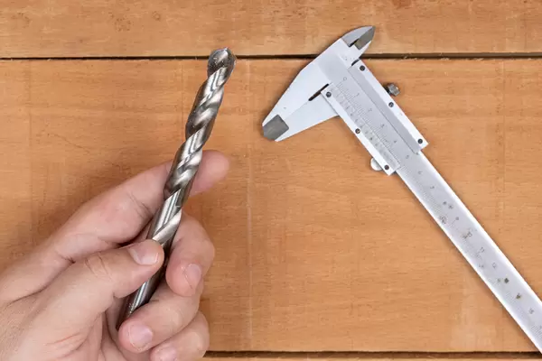 Large Metal Drill with Caliper on the table