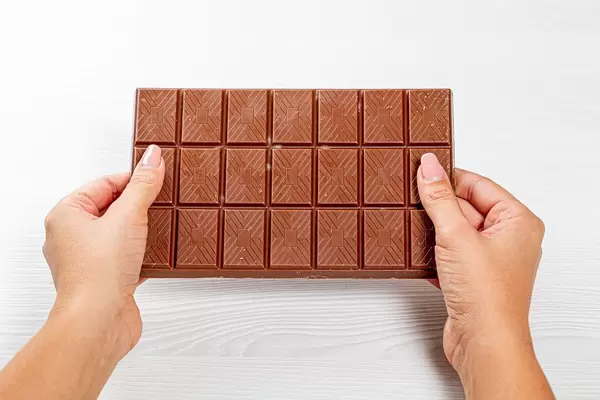 Large milk chocolate in women's hands