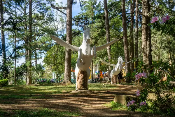 Large Pegasus Statues in a Park with Tall Trees, Plants and Flowers at the Bao Dai King Palace in Da Lat, Vietnam