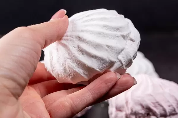 Large white marshmallows in a female hand