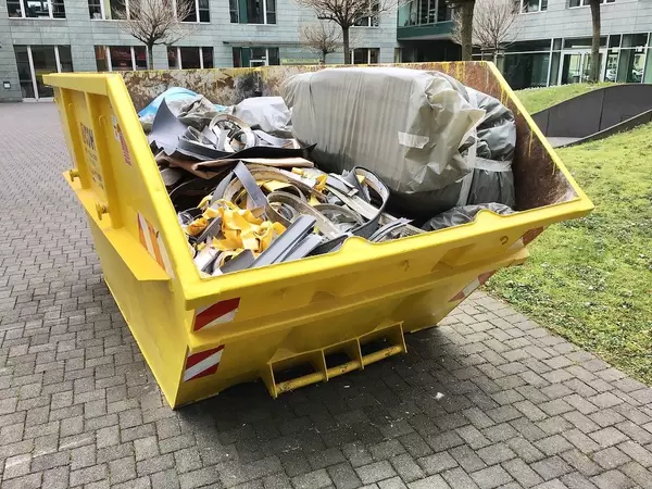 Large Yellow Trash Container filled with Construction Waste