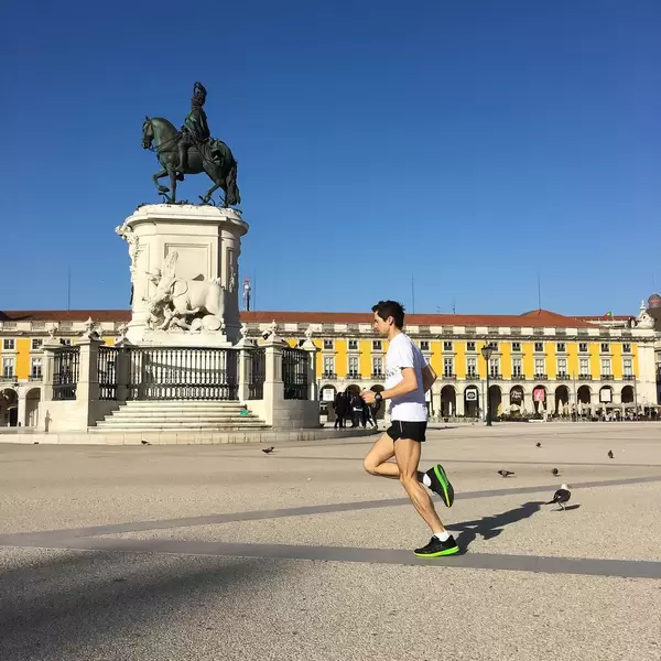 Läufer am Praça do Comércio Platz mit der Reiterstatue (Joseph I) im Hintergrund - Lissabon, Portugal