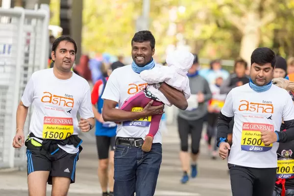 Läufer mit einem Baby in seinen Händen - Frankfurt Marathon 2017