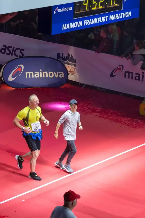 Läufer und ein Junge überqueren die Ziellinie - Frankfurt Marathon 2017