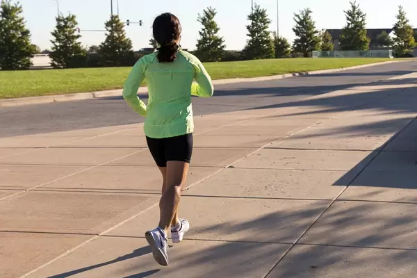 Läuferin in schwarz-grüner Sportbekleidung