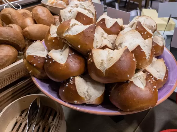 Laugenbrötchen auf einem Teller stehen zum Servieren bereit an einem Buffet