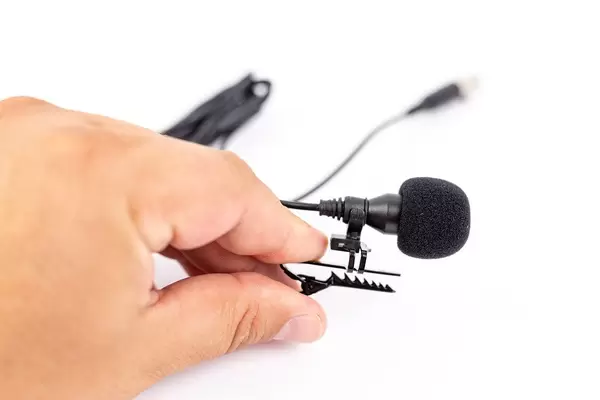 Lavalier Microphone in the hand above white background