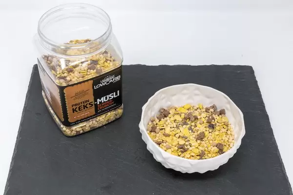 Layenberger Low Carb Protein Keks-Müsli in der Variation Schoko Crunchy mit Produkt auf Schieferplatte