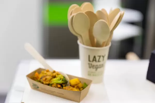 Lazy Vegan Kostprobe und ein Becher mit Holzlöffeln