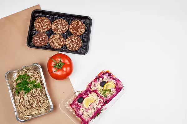 Lebensmittelspenden: Kekse, eine Tomate, Nudeln und Rote-Bete-Oliven-Gericht in Einwegverpackung