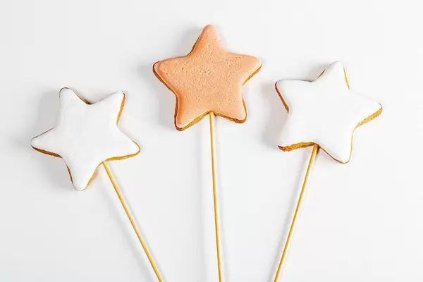 Lebkuchen Sterne auf Holzstäben vor weißem Hintergrund