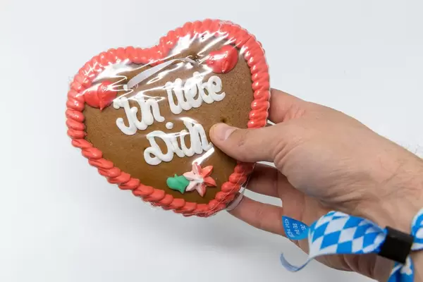 Lebkuchenherz vom Oktoberfest mit der Schrift - Ich Liebe Dich - gehalten von einer Hand