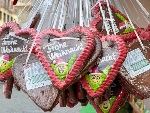 Lebkuchenherzen mit "Frohe Weihnacht" Schrift und rotem Rand bei einem Verkaufsstand