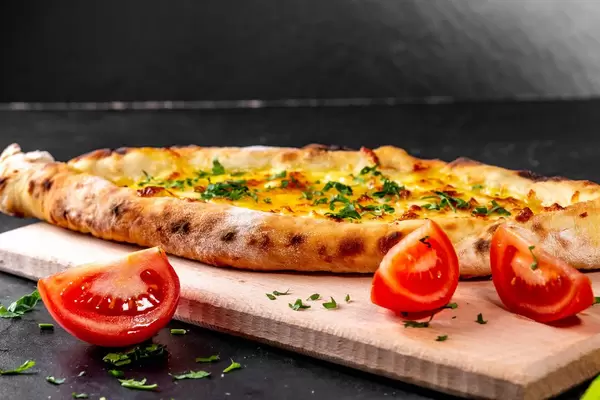 Leckere gebackene Adygei-Khachapuri mit Käsenteig und Kräutern