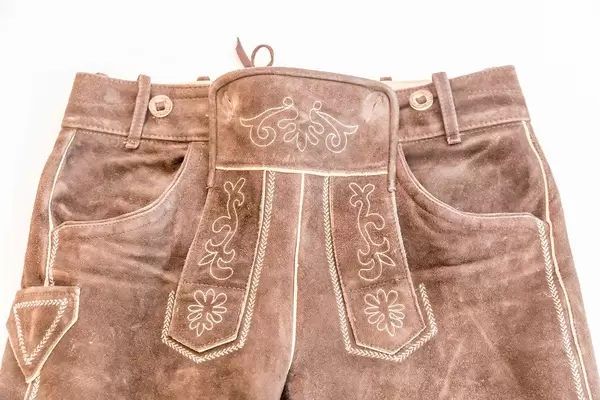 Lederhose flach liegend in dunklem braun mit Verzierungen