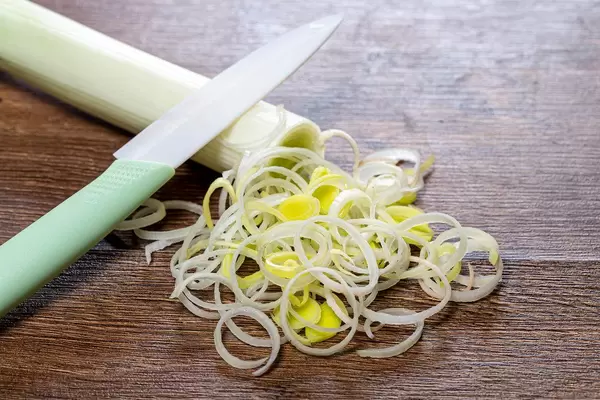 Leeks cut into rings with a knife on the kitchen table (Flip 2019)