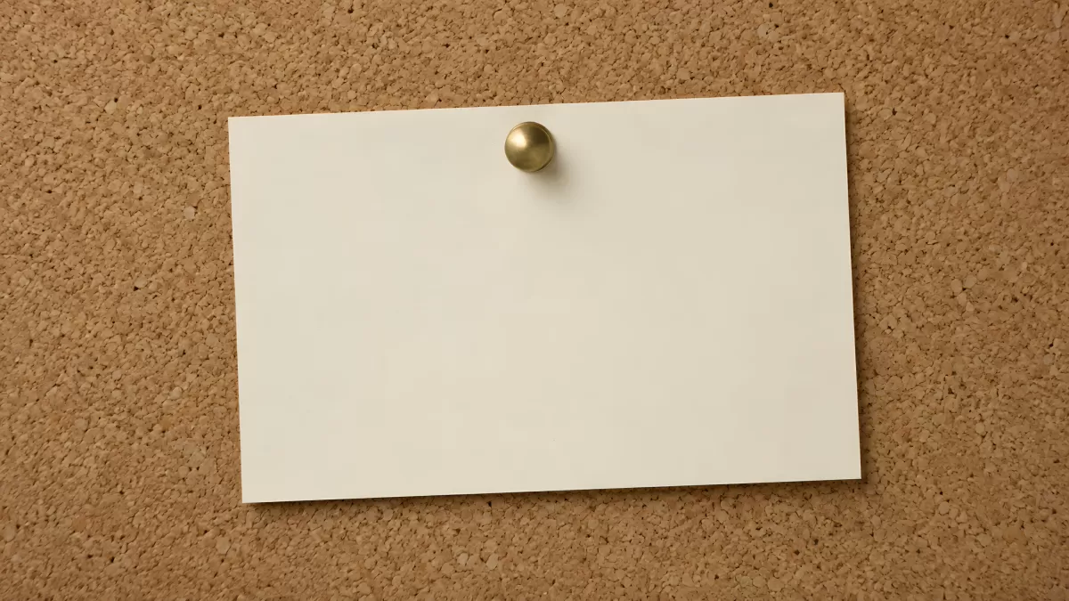 Leere Notizzettel an Pinnwand mit goldener Reißzwecke