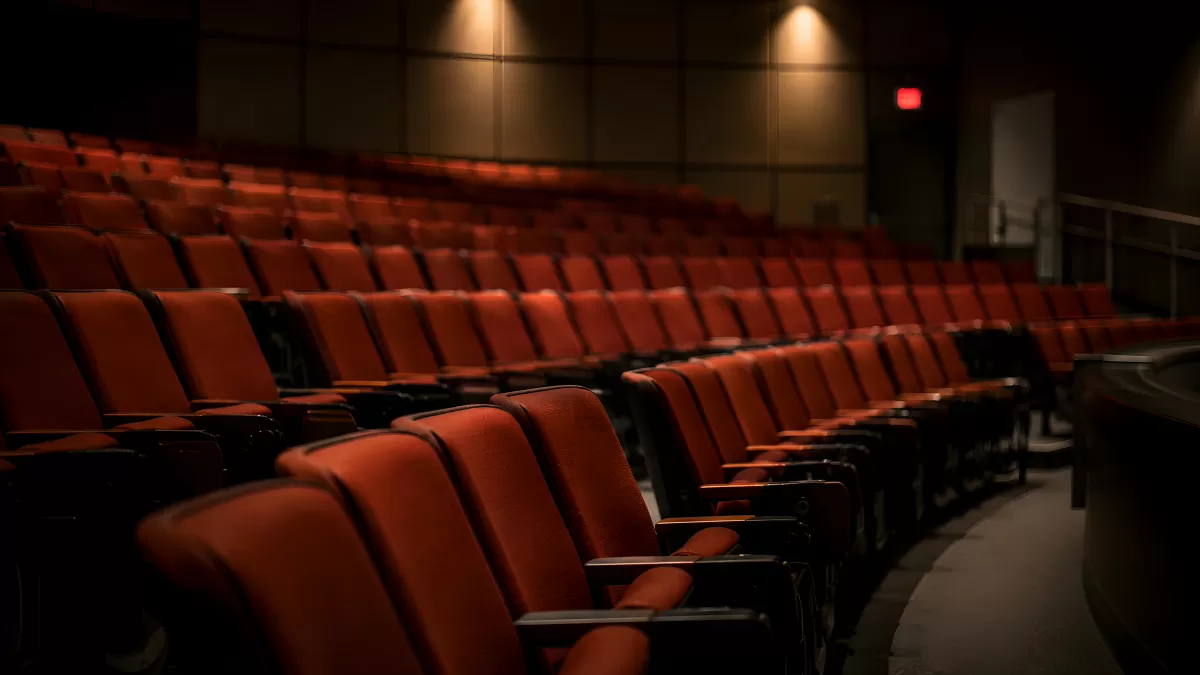 Leere rote Kinosessel in einem dunklen Theatersaal