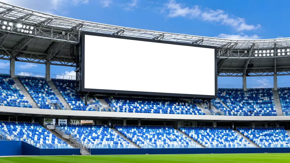 Leere Stadionränge mit großer Videoleinwand
