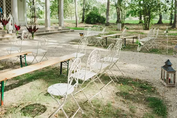 Leere Stühle bei einer Hochzeitszeremonie unter freiem Himmel
