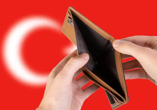 Leerer Geldbeutel aus Leder mit Flagge der Türkei. Rezession und Finanzkrise werden mit mehr Schulden und Bundeshaushaltdefizit einhergehen