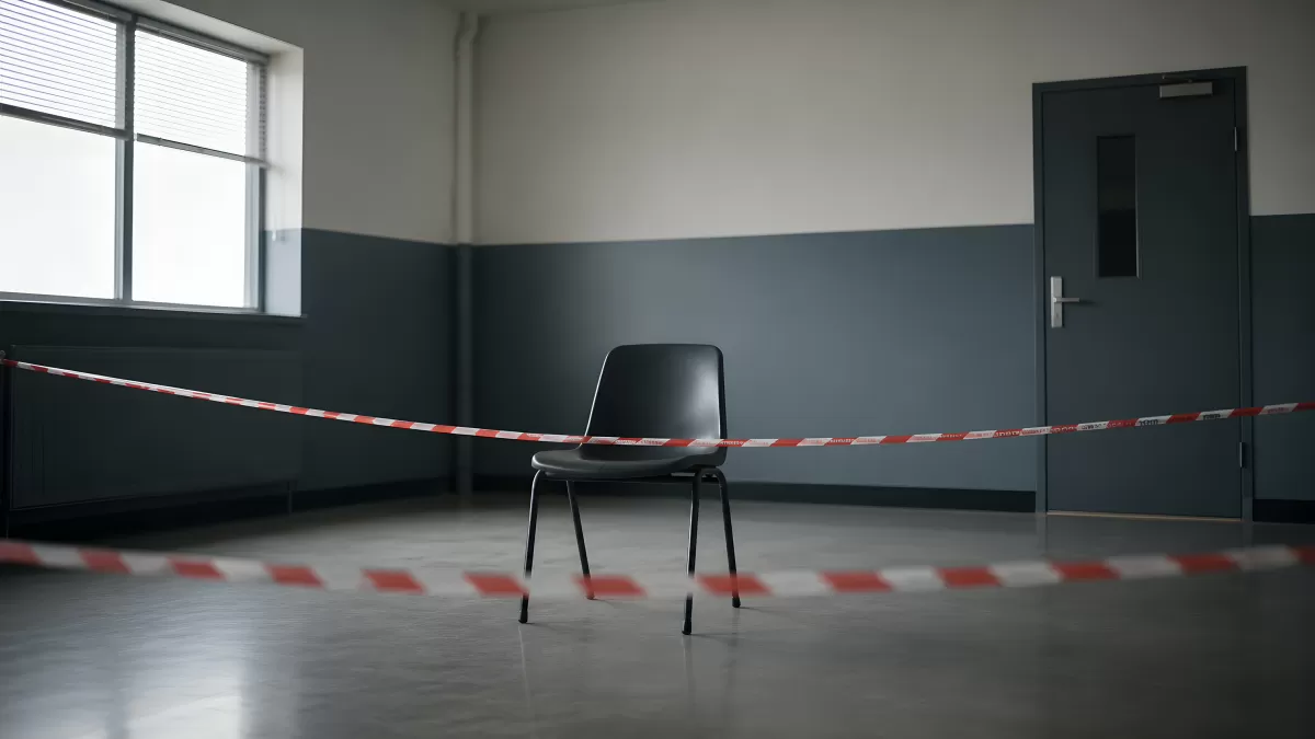 Leerer Stuhl hinter Absperrband in verlassenem Raum