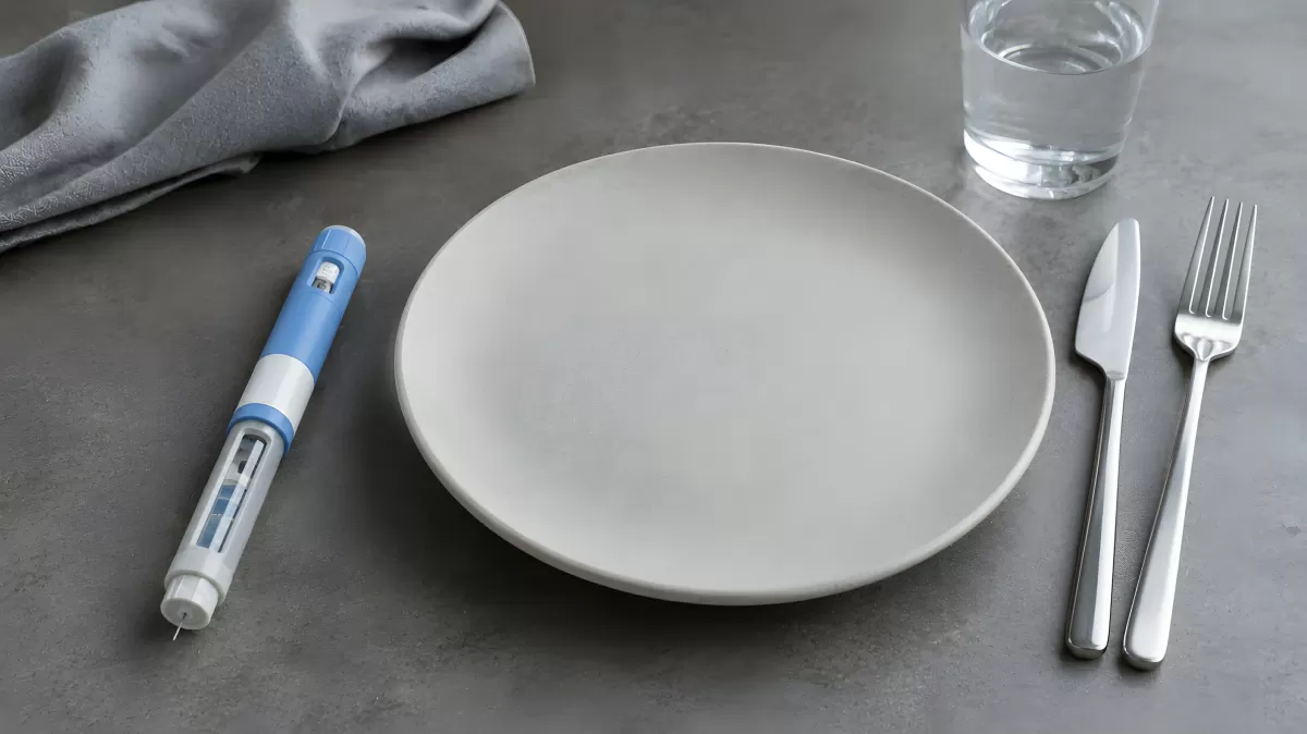 Leerer Teller mit Insulinpen beim Abendessen