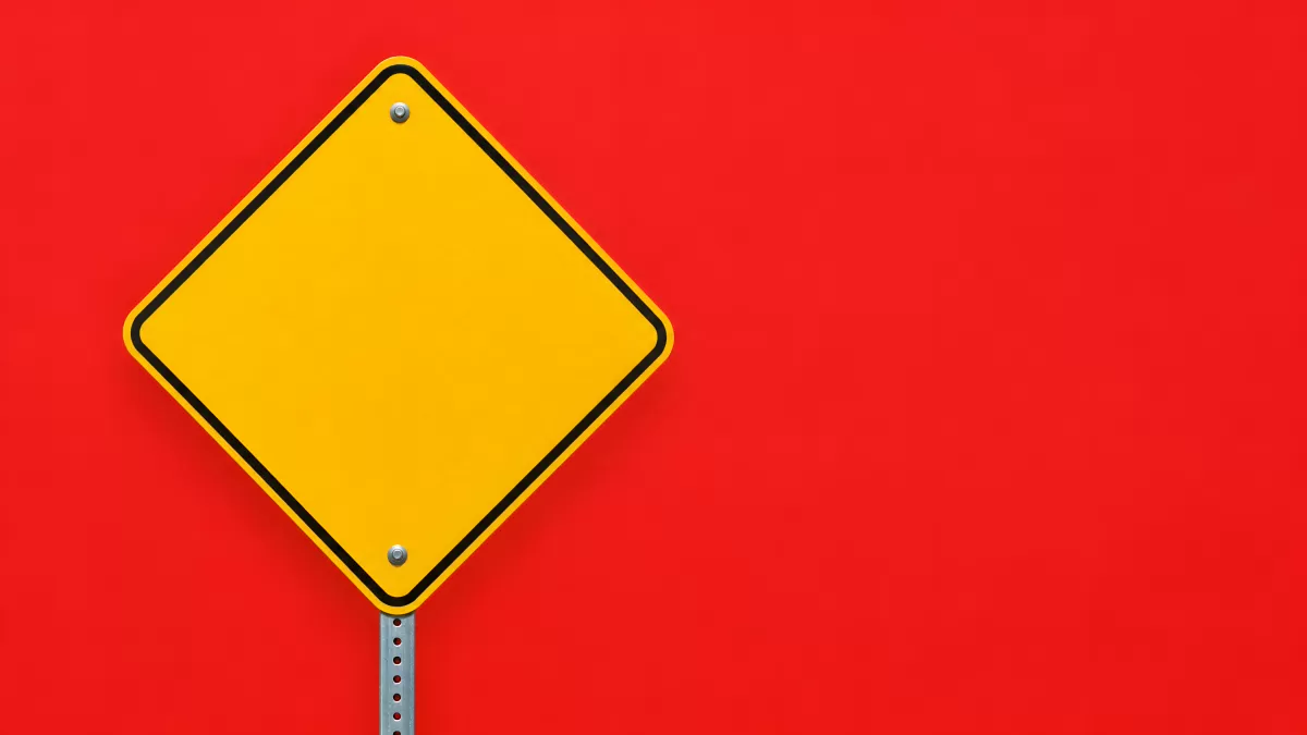 Leeres gelbes Warnschild vor rotem Hintergrund