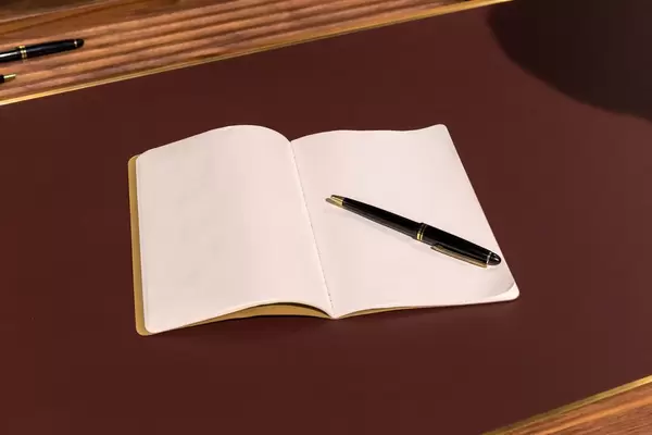 Leeres Heft mit edlem Kugelschreiber auf luxuriösem Tisch