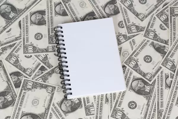 Leeres Notizbuch mit Ringbindung liegt auf 100 US-Dollar Noten