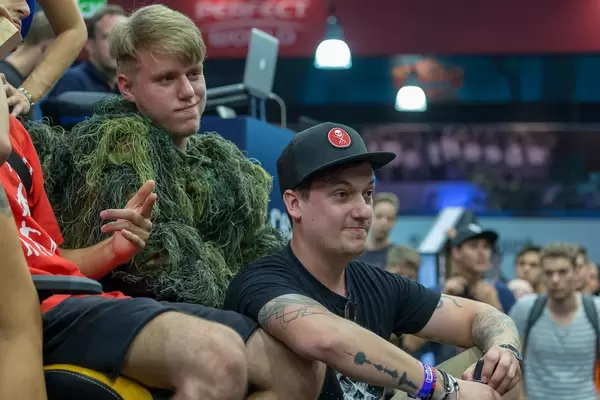 LeFloid sitting next to Gamescom visitors and watching a Jenga game unfold