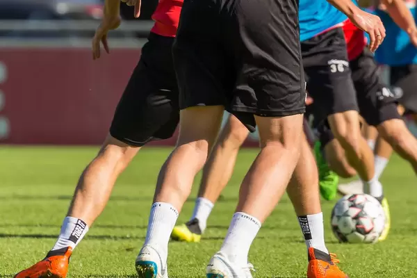 Legs of football players on a pitch during training