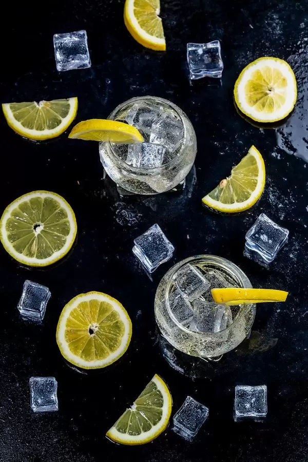 Lemonade with ice cubes and sliced lemon on black background. Top view (Flip 2019)