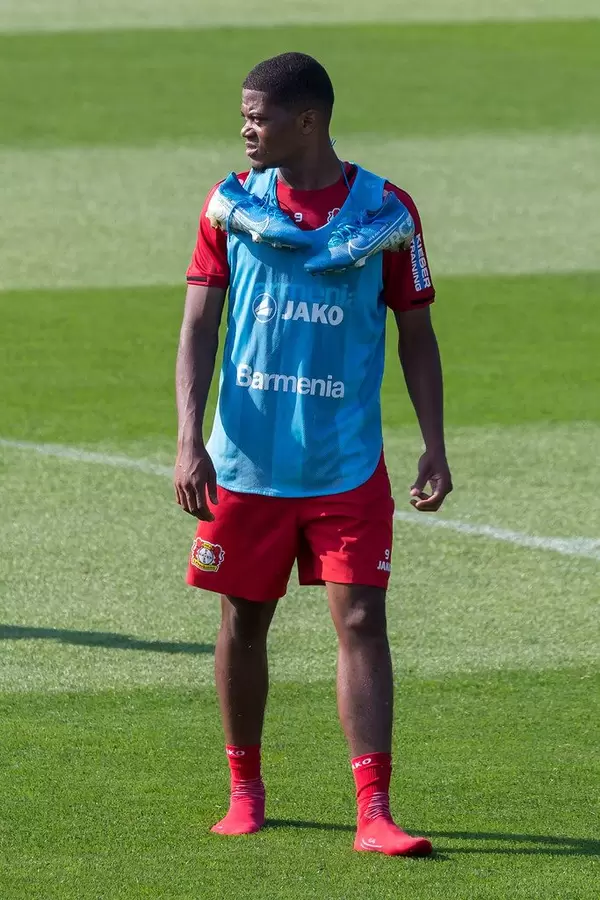 Leon Bailey in Socken auf dem Fußballfeld, mit umgehängten Fußballschuhen, während dem Mannschaftstraining