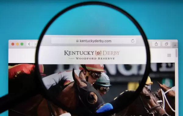 Leselupe über Logo und Internetadresse des Kentucky Derby auf PC-Bildschirm