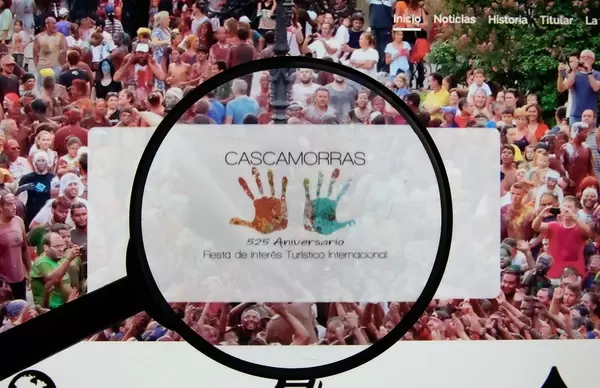 Leselupe weist auf Logo des Cascamorras Festivals in Spanien auf entsprechender Internetseite