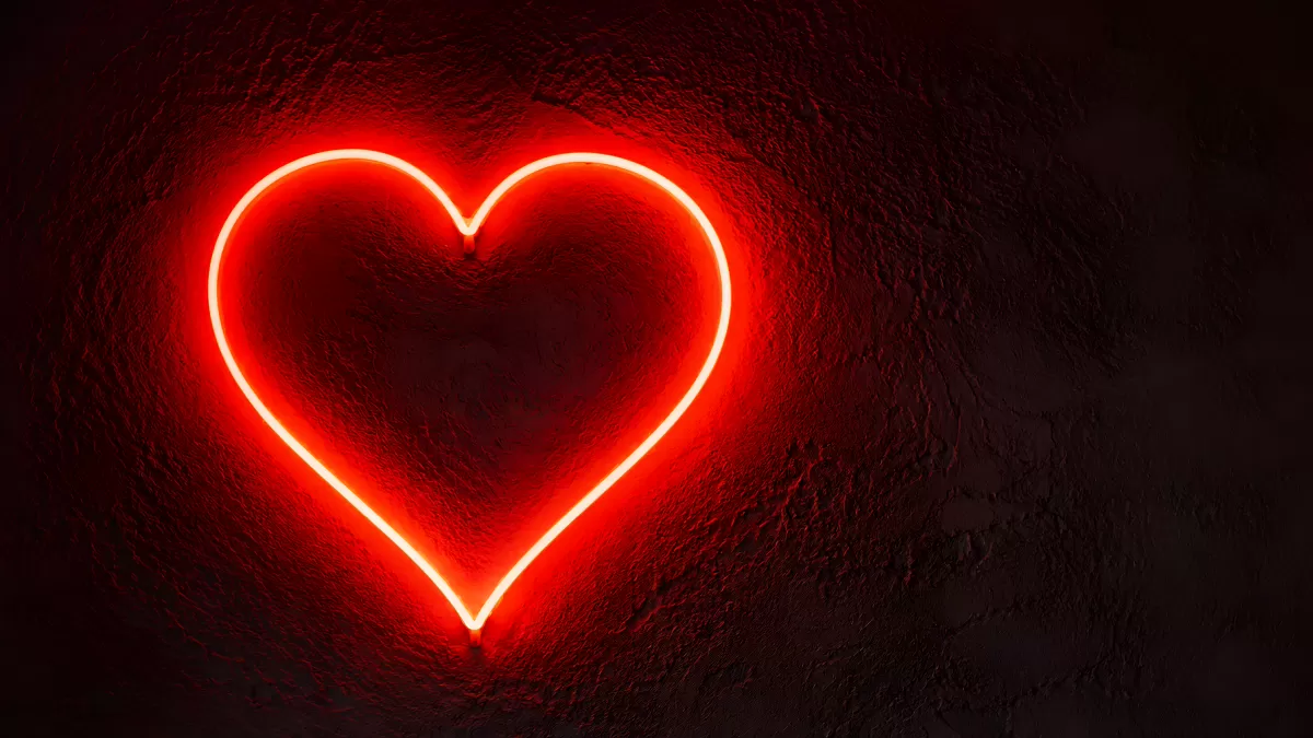Leuchtendes Neon-Herz an dunkler Betonwand