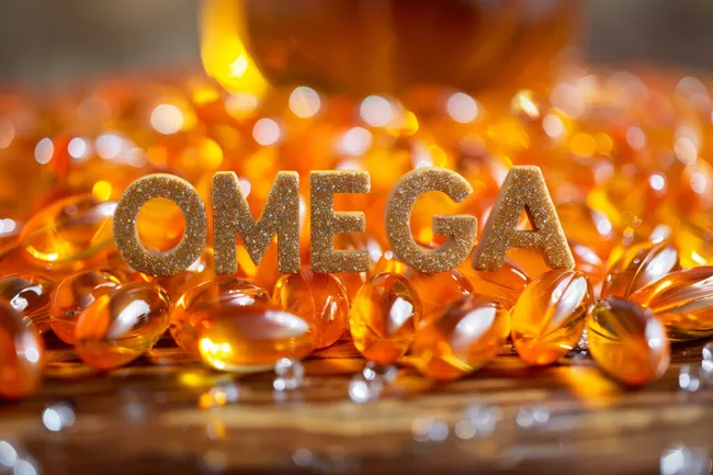 Leuchtendes Omega-Symbol aus glitzernden Buchstaben