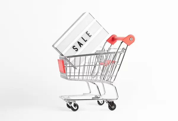 Leuchtreklame mit der Aufschrift SALE in Einkaufswagen symbolisiert Schlussverkauf