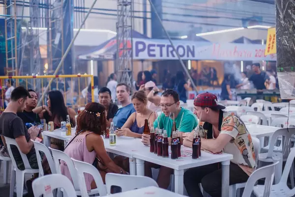 Leute aus verschiedenen Ländern sitzen an einem Tisch in den Phillippinen mit einer Menge Flaschen Pepsi