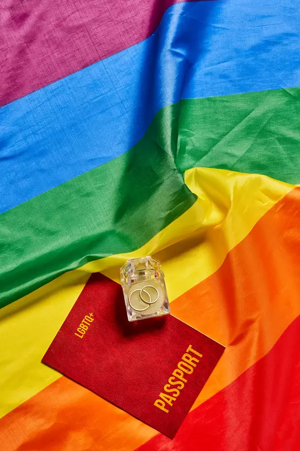 LGBTQ+ people marriage, wedding concept with passport, ring and rainbow flag
