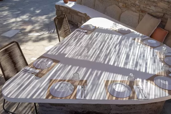 Licht-und Schattenspiel auf einem gedeckten Tisch auf der Außenveranda eines Restaurants auf Paros, Griechenland