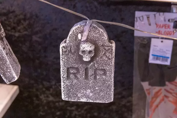 Lichterkette mit Totenkopf und "RIP" Schriftzug auf kleinen Steinen als Leuchtelement