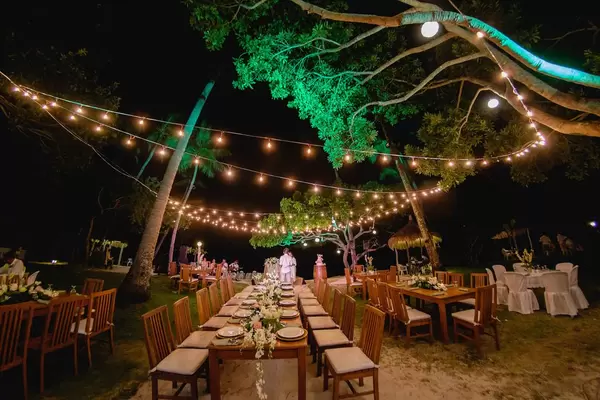 Lichterketten überdachen die Tische einer Hochzeit bei Nacht in Punta Bulata