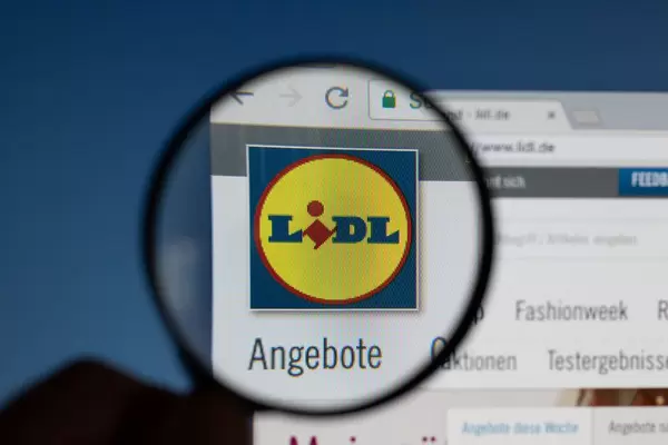 Lidl-Logo am PC-Monitor, durch eine Lupe fotografiert