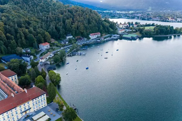 Liegeplatz für Segelboote mit zwei kleinen Seebrücken am Tegernsee. Luftaufnahme im Herbst