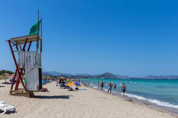 Lifeguard tower on the beach of Can Picafort in Mallorca with many tourists in summer 2020